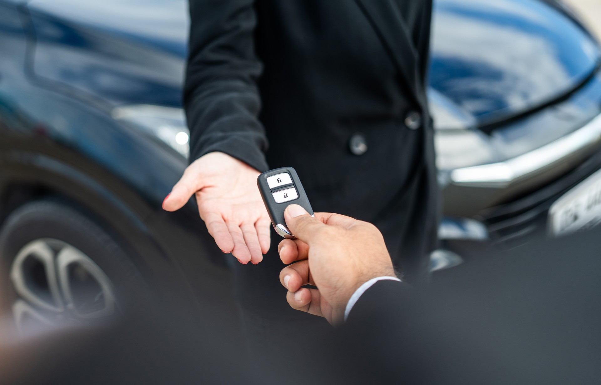Young asian businesswoman buying new car with sale manager. she getting key and go to driving car very happy and proud. Buy sell rent concept. Hand sending key vehicle contract business car deal